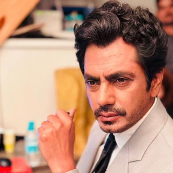 পরনে ঝলমলে পোশাক। ঠোঁটে গাঢ় লাল রঙের লিপস্টিক। বাঁ হাতে পোশাকের সঙ্গে মানানসই আংটি এবং ব্রেসলেট। চোয়ালের রেখায় বিরক্তির ভাঁজ। চোখ থেকে যেন আগুন ঠিকরে বেরিয়ে আসছে। সিংহাসনে লাস্যময়ী মেজাজে বসে এক নারী। নারী বললে ভুল হবে। আসলে নারীর বেশে রয়েছেন বলি অভিনেতা নওয়াজ়উদ্দিন সিদ্দিকি।