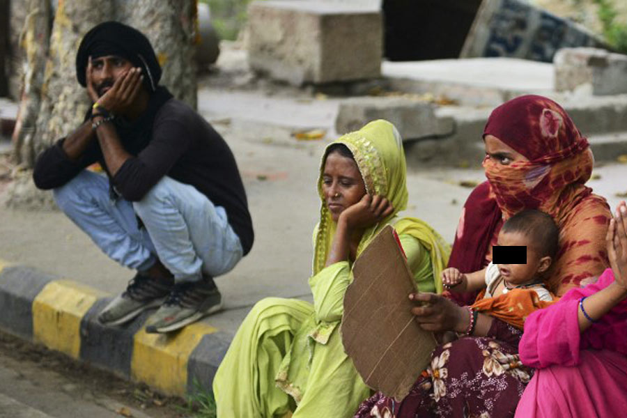 Image of Indian people sitting on a footpath 