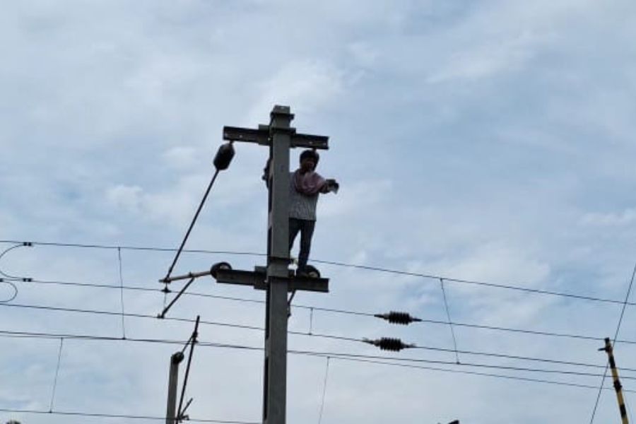 Man climbs up to electric post of Bankura Rail station