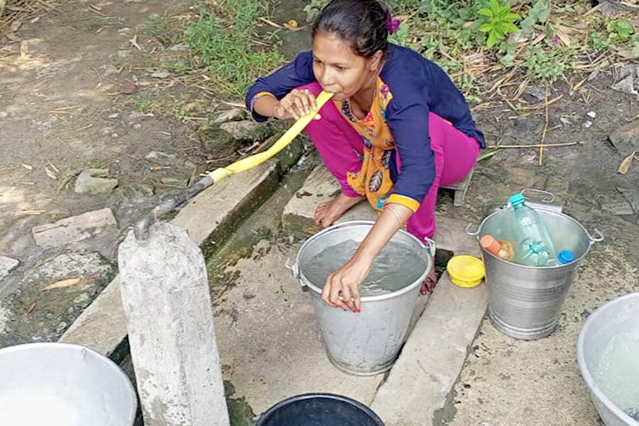 A local resident from Bagnan trying to pump out water by blowing the pipe