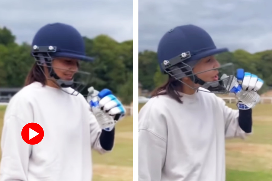 Bollywood actress Anushka Sharma struggles to drink water with a cricket a helmet on 