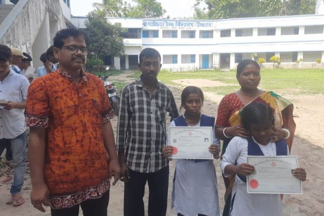স্কুলের প্রধান শিক্ষকের সঙ্গে যমজ কন্যা ও পরিবার। নিজস্ব চিত্র।