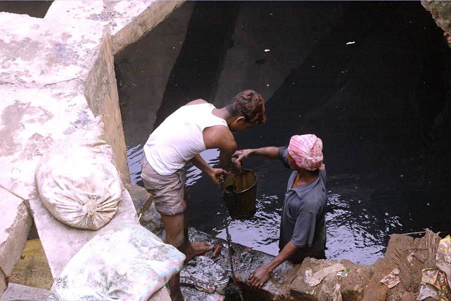 খোলা ড্রেন থেকে আবর্জনা তোলা হচ্ছে উত্তর ২৪ পরগনার ইছাপুরে।