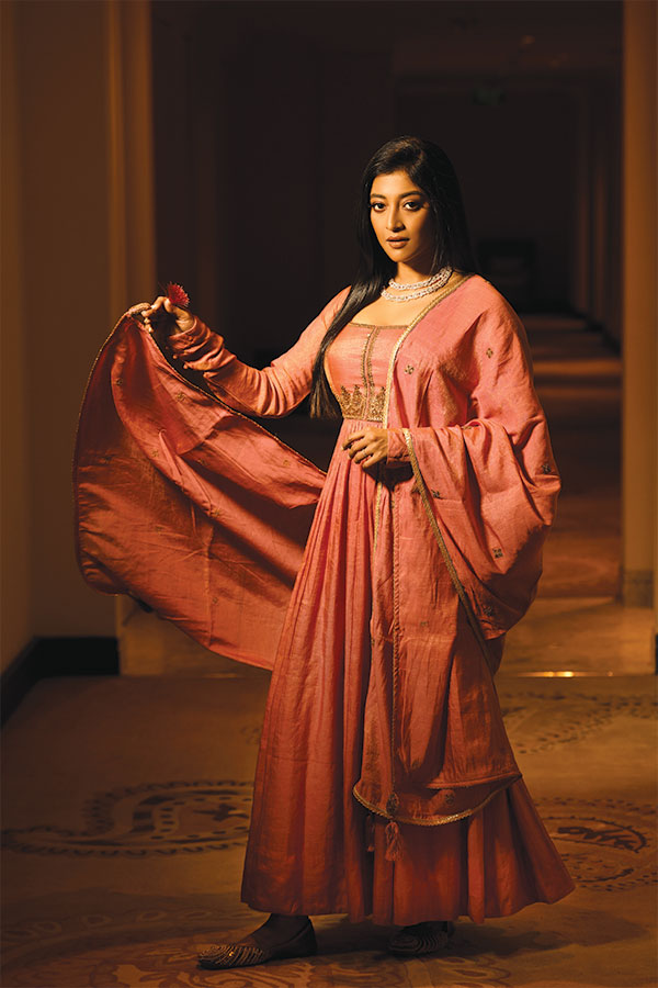 মটকা সিল্কের গাঢ় পিচ-গোলাপি আনারকলি পরে পাওলি নিজের খেয়ালে ডুবে। আনত চোখ কী মিষ্টি হাসি,  সবেতেই তিনি মোহময়ী। সোনালি জরির কাজে ঠাসা আনারকলি আর একই রঙের ওড়না,  তাতেই তিনি অপরূপা। 