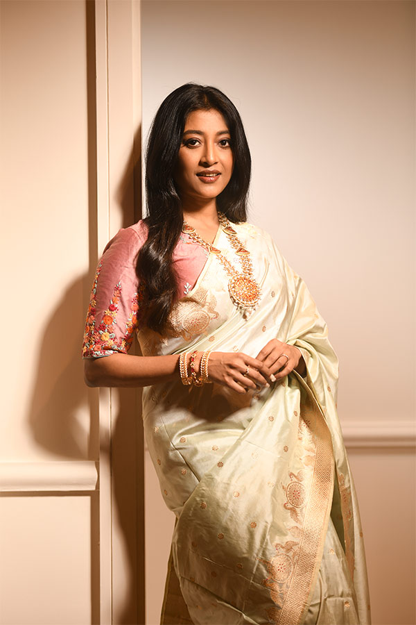 গোলাপি পিঠঢাকা ব্লাউজ। পাঊডার গোলাপি শাড়িতে নানা রকম সুতোর কাজ,  হাতায় ও পিঠে ঠাসা কাজের সঙ্গে এক রঙা ঢালা শাড়ি দারুণ মানিয়েছে। 