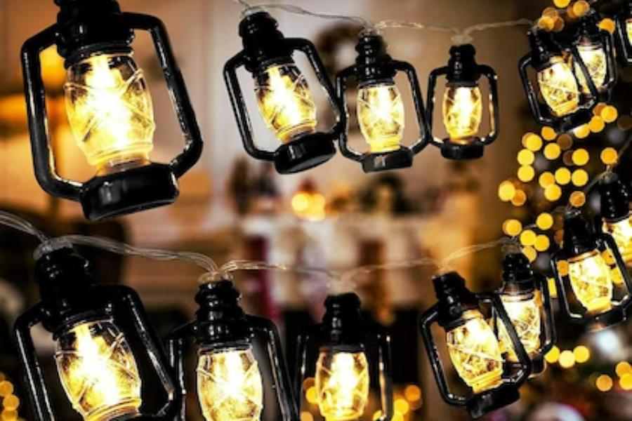 হ্যারিকেন আলো: লম্বা একটি আলোর চেন। তাতে ছোট ছোট হ্যারিকেন লাগানো। তবে এই হ্যারিকেন কিন্তু তেলে জ্বলে না।  হ্যারিকেনগুলির মধ্যেই রয়েছে ছোট ছোট আলো। সেগুলি সব একটি তার দিয়ে জোড়া। প্লাগে ঢুকিয়ে এমন আলো দিয়েই কিন্তু সাজিয়ে নিতে পারেন আপনার বারান্দা বা ঘরের কোনও একটি দেওয়াল। দিওয়ালির রাতে হ্যারিকেনের আলোয় বেশ অন্য রকম দেখাবে আপানার বাড়ি।