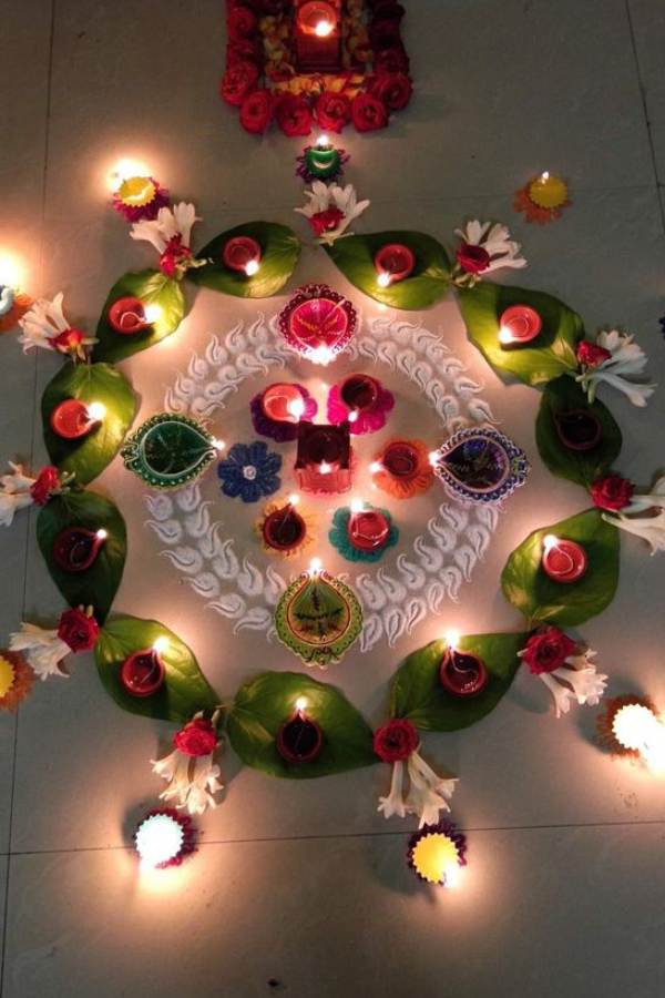 গাঁদা ফুল দিয়ে তো সবাই রঙ্গোলি করে। আপনি বরং আনুন একটু নতুনত্ব। হলুদ বা কমলা গাঁদা ফুলের সঙ্গে যোগ করুন রজনীগন্ধা এবং গোলাপের। সঙ্গে পান পাতা হোক দোসর। ব্যস তারপর আর কি,  সহজেই বানিয়ে নিন এই নকশা। প্রদীপ দিতে ভুলবেন না কিন্তু। 