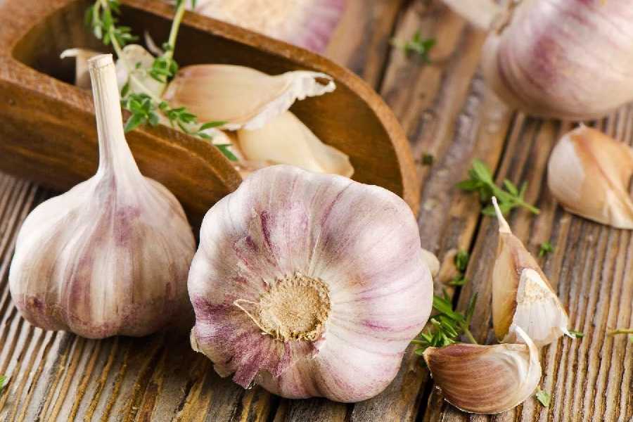 What is the role of raw garlic in cholesterol management