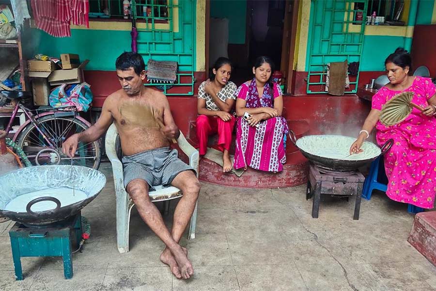 বাবা ও মা রাবড়ি তৈরি করছে দুই মেয়ে পাশে বসে।