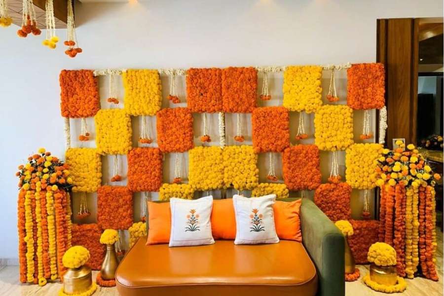 গাঁদার সাজ: ফুলের মধ্যে সবচেয়ে সহজ এবং জনপ্রিয় হল গাঁদা ফুলের সজ্জা। প্রধানত হলুদ এবং কমলা রঙের এই ফুলের মালার সঙ্গে টাটকা সবুজ পাতায় ঘরে আসুক তরতাজা ভাব। সঙ্গে হালকা, অর্থাৎ কম পাওয়ারের বাল্ব জুড়ে ঘর সাজালে বিশেষত সন্ধেবেলায় প্রাণবন্ত দেখতে লাগে। বড় হলঘরের মাঝখানে কার্পেট বিছিয়ে তার ঠিক মধ্যিখানে গাঁদা দিয়ে সাজালেও অসাধারণ দেখায়। গাঁদা ফুল ২-৩ দিন তাজা থাকে। তাই রোজ রোজ ফুল পাল্টানোর দরকার পড়ে না।