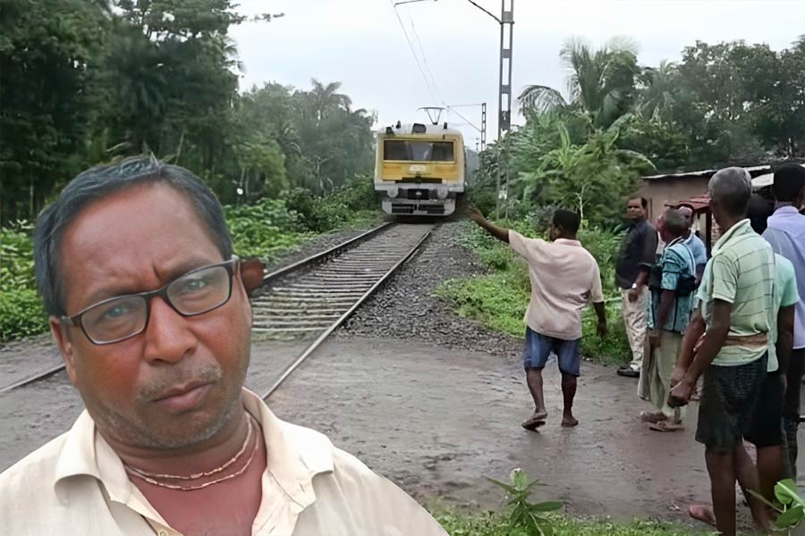 Nanigopal Debnath of Santipur warns passengers at the railway gate.