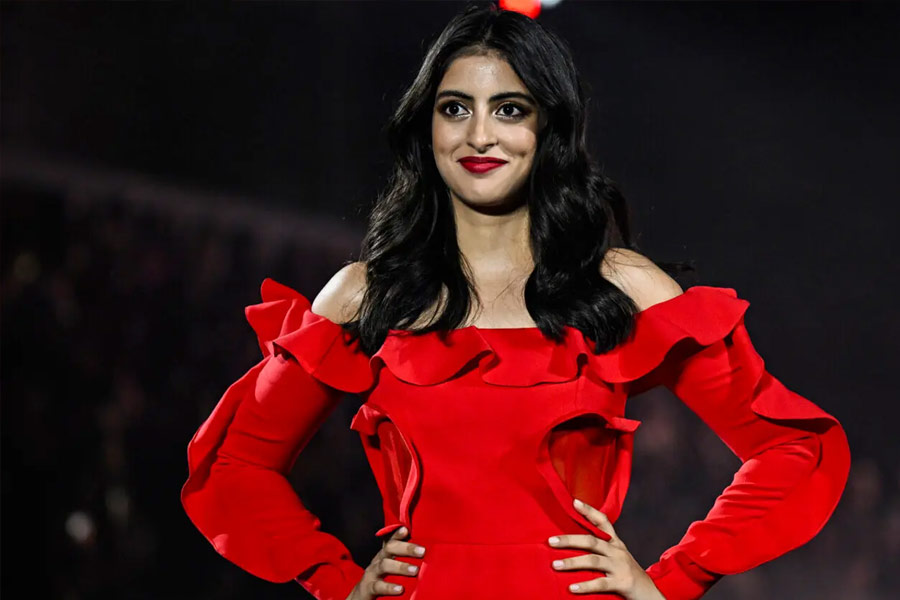 লাল রঙের একটি অফ-শোল্ডার মিনিড্রেস পরে র‌্যাম্পে হাঁটতে দেখা যায় নব্যাকে।