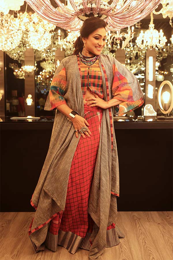 গামছা প্রিন্টের রংবেরঙের টপ আর স্কার্টের সঙ্গে মানানসই ধূসর রঙের কাফতান ঢঙের শ্রাগ,  সব মিলিয়ে তাঁর সাজ যেন সপ্তমীর সন্ধের তুমুল আড্ডার জন্যই তৈরি। 