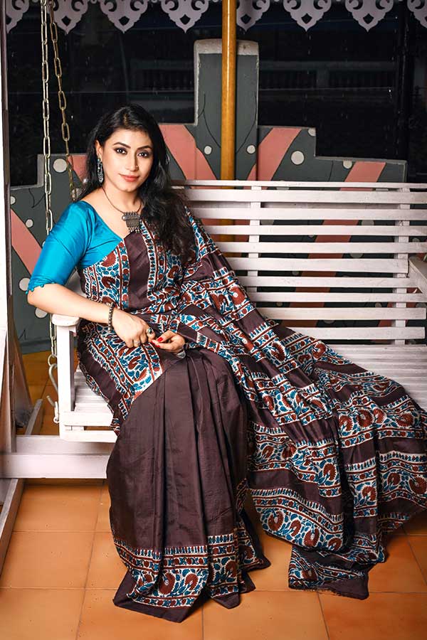 নবমীর দিনের সাজ হবে একটু আধুনিক ধাঁচের। সেই মতো সৈকত বন্দ্যোপাধ্যায় সাজিয়েছেন, বাদামী ও নীল রঙের অ্যাসিড ব্লক প্রিন্টের প্যানেল করা বিষ্ণুপুর সিল্কের শাড়িতে। সাবেকি ঘরোয়া সাজের বাইরে একটু আধুনিকা শাড়ির সাজ এটি। মুঘল স্থাপত্যের জাল কাজ করা জানলার মতো কারুকাজ ফুটিয়ে তুলেছেন এই শাড়িতে। 