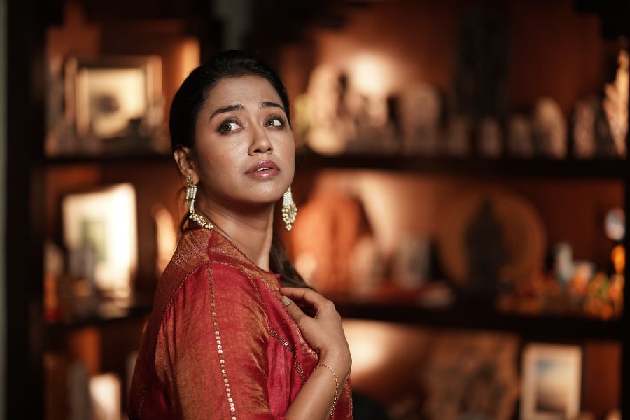 গয়নার বাহুল্য নেই। কানে মুক্তো সঙ্গে সোনালি বড় জরোয়া কাজের দুল। লালে-সাদায় তাঁর সাজ যেন বলে ওঠে “নবমী নিশি না হইয়ো ভোর!” এই প্রতিবেদনটি ‘আনন্দ উৎসব’ ফিচারের একটি অংশ। 