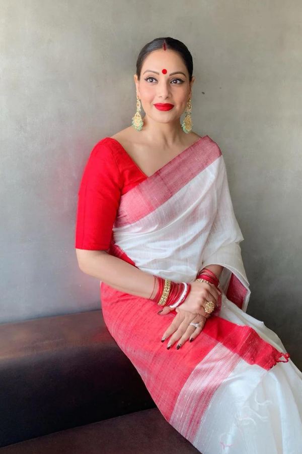 রূদ্র সাহা বললেন, ‘‘নব বিবাহিতাদের জন্য লক্ষ্মীপুজোর সাজে থাকুক লাল টকটকে ব্লাউজের সঙ্গে লাল পাড় সাদা শাড়ি। সঙ্গে বিয়ের বহু গয়না একসঙ্গে পরে নিন,  যাকে বলে গা ভরা সোনার গয়না পরা,  একদম সেই রকম। গলায় চোকার,  চেন আবার হাতে শাঁখা-পলা ইত্যাদি থাকুক।’’ 