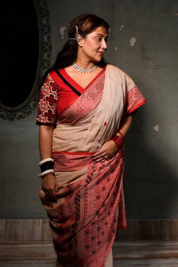 আলো আঁধারি ঘর। সেখানেই একলাটি তিনি। গায়ে মেটে রঙের চওড়া লাল পেড়ে শাড়ি। সুতোর কাজ করা হাতার লাল রঙা ব্লাউজ। পিঠ ছাপানো এক ঢাল খোলা চুল। 