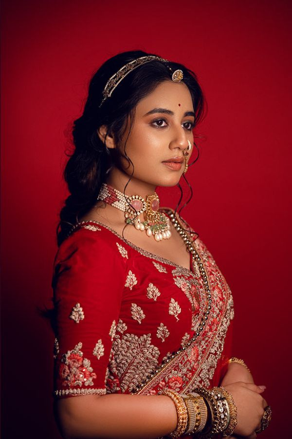 লাল রঙের ভারী জারদৌসী কাজের লেহেঙ্গা ও ব্লাউজকে সঙ্গত দিয়েছে কোমর ছুঁয়ে আটকানো ফুরফুরে স্বচ্ছ লাল ওড়না। 