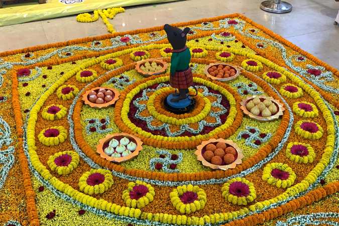 সামনেও বড় বানানো হয়েছে ফুলের রঙ্গোলি। নানা রঙের ফুলে সেজে উঠেছে মন্ডপ। 
