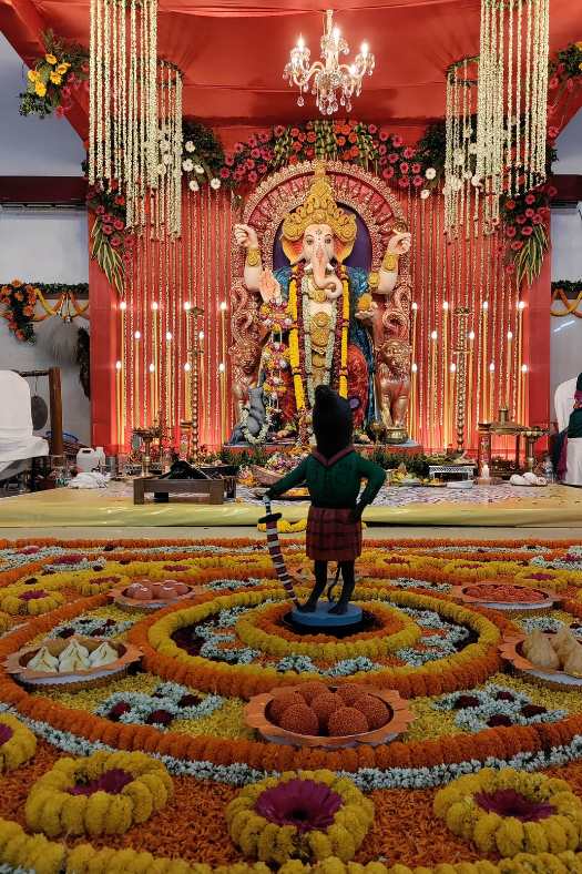 সিদ্ধিদাতার পরণে রয়েছে নীল কাপড়। হাতে বড় মোদক। তিনি এখানে সিংহাসনে আসীন। আবার হাতলেও রয়েছে সিংহের মুখ। 