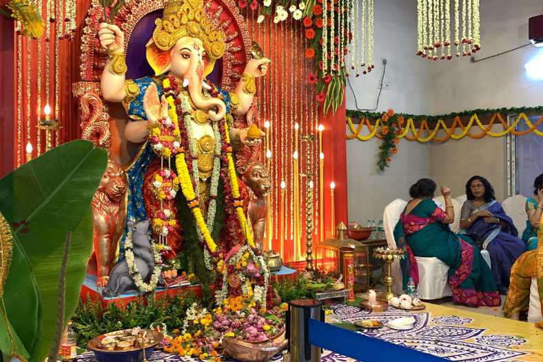 আলপনার সাজে সেজে উঠেছে মূর্তির সামনের অংশও। আবার রঙ্গোলির মধ্যে বসানো রয়েছে লাড্ডু এবং মোদকের থালা। 