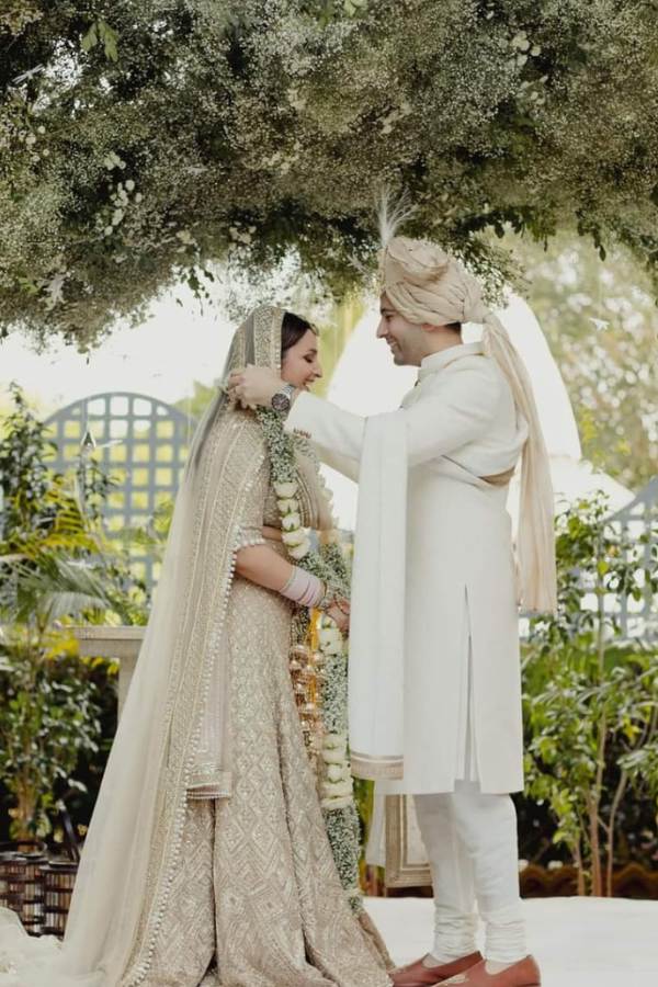 পরিণীতি পরেছেন পোশাকশিল্পী মণীশ মলহোত্রর সাদা ও সোনালী কারুকাজ ও নকশার লেহেঙ্গায় সেজেছিলেন তিনি। ভারী পাথরের হালকা রঙের গয়নায়,  বিয়ের কনের সাজ ছিল বেশ ছিমছাম। 