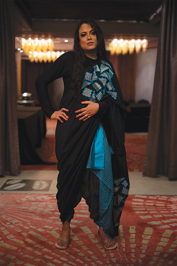 কিজু সাহাও নিজের সাজ নিয়ে বেশ সচেতন। পুজোর দিনে চাই অন্য রকম সাজ, তাই শুধু শাড়ি নয়, শাড়ি পরার ধরনেও থাকতে হবে অন্য ধারা। নীল ও কালো রঙের শাড়ি তাই তিনি পরেছেন ধুতির মতো করে। 