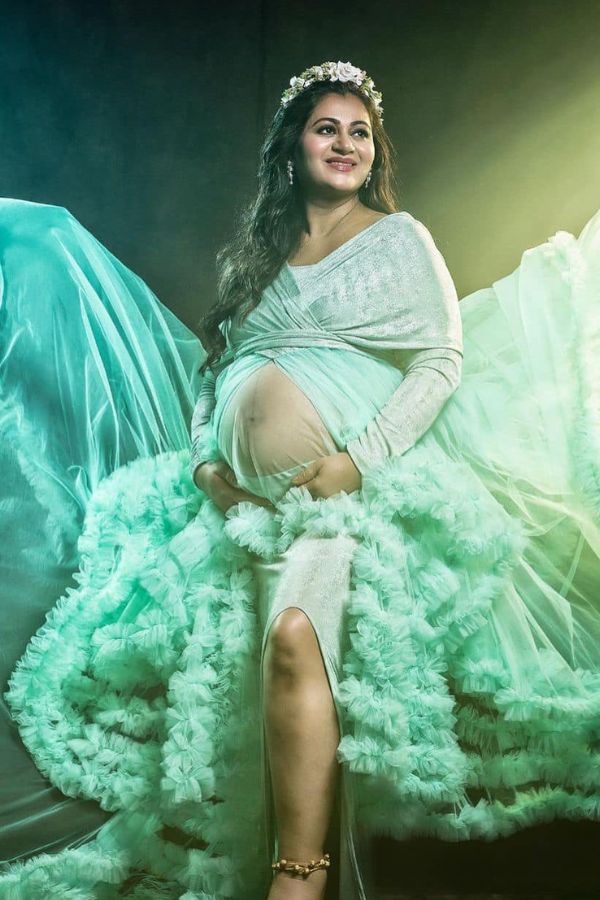 অপ্সরার মতো স্বচ্ছ সমুদ্র নীল রঙের গাউন ও ফুলেল হেডব্যান্ডে মোহনাকে আরও অনবদ্য দেখাচ্ছে। মাতৃত্বের উজ্জ্বলতা যেন তাঁর চোখে মুখে ফুটে উঠছে। 