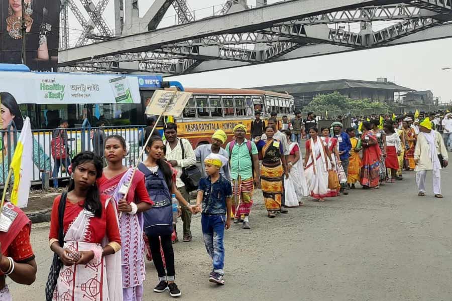 শুক্রবার সকাল ৯টা নাগাদ হাওড়া সেতুর উপরে পতাকা নিয়ে দাঁড়িয়ে থাকতে দেখা যায় আদিবাসী সমাজের প্রতিনিধিদের। তাঁদের দাবি, কুড়মি-মাহাতোরা জোর করে তফসিলি জনজাতি (এসটি)-র তকমা পেতে চাইছে। রাজনৈতিক মদতও পাচ্ছে তারা।