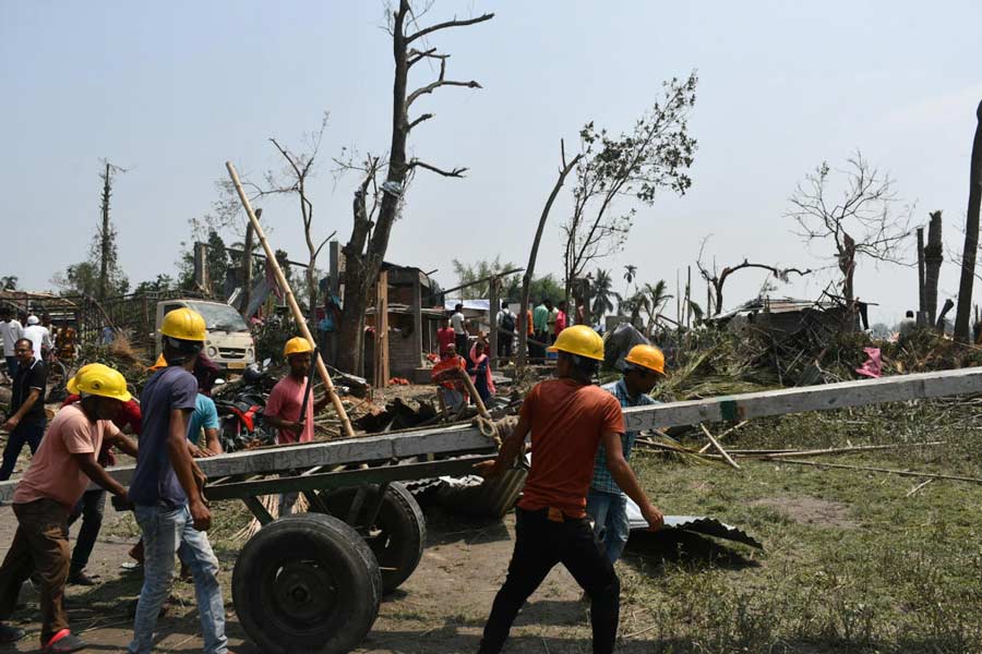ঝড়ে বিপর্যস্ত এলাকায় বিদ্যুৎ পরিষেবা স্বাভাবিক করার চেষ্টা। সোমবার ময়নাগুড়িতে। 