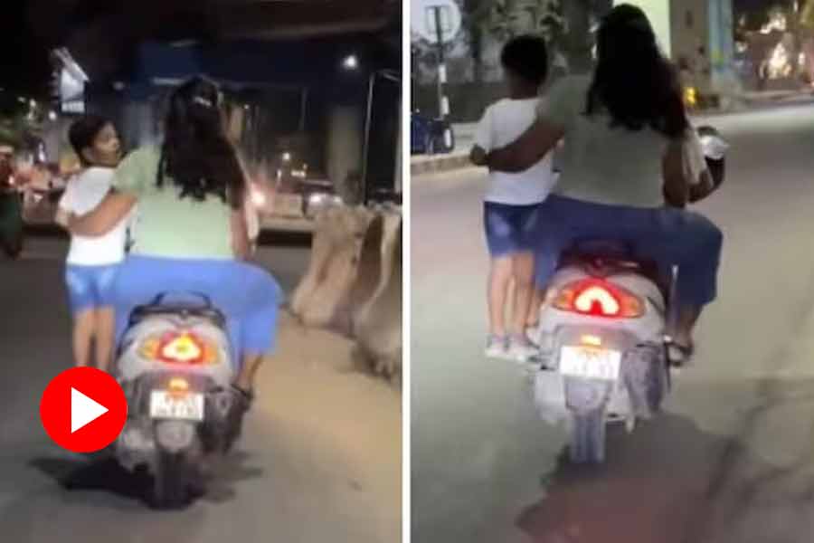 Couple rides bike with child standing on footrest in Bengaluru