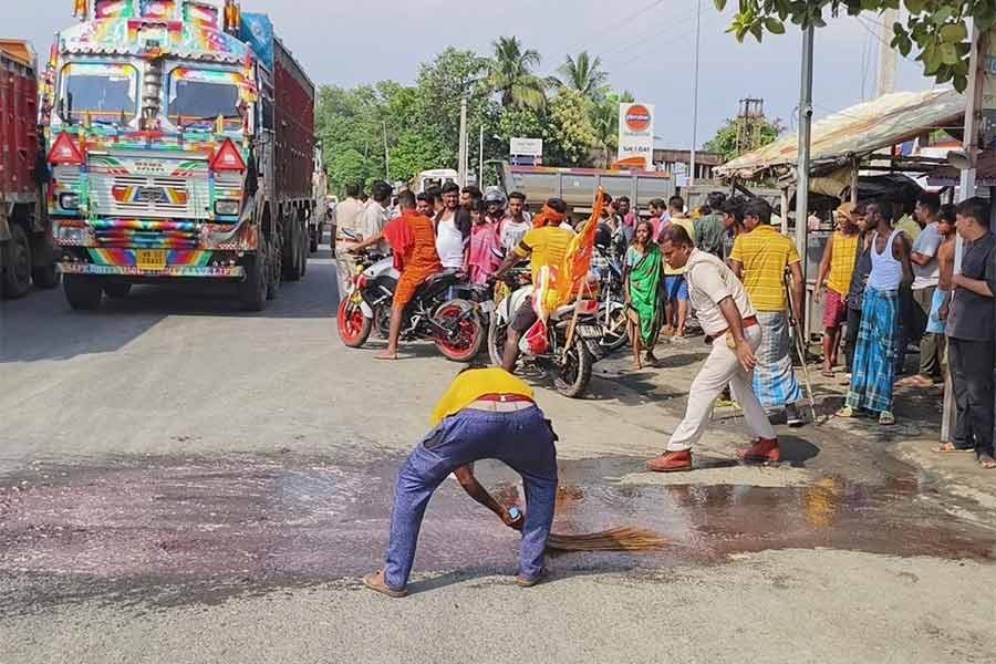 ১৪ নম্বর জাতীয় সড়কের এখানেই ট্রাকের ধাক্কায় মারা যান দুই বাইক আরোহী। ঘটনাস্থলে রক্তের দাগ পরিষ্কার করা হচ্ছে। বুধবার। নিজস্ব চিত্র