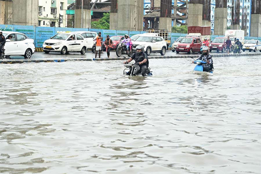 দুর্ভোগ: মোটরবাইক, স্কুটারের চাকা ডুবেছে জলে। সেই অবস্থাতেই কোনও ক্রমে যাতায়াত। শনিবার, ভিআইপি রোডে।