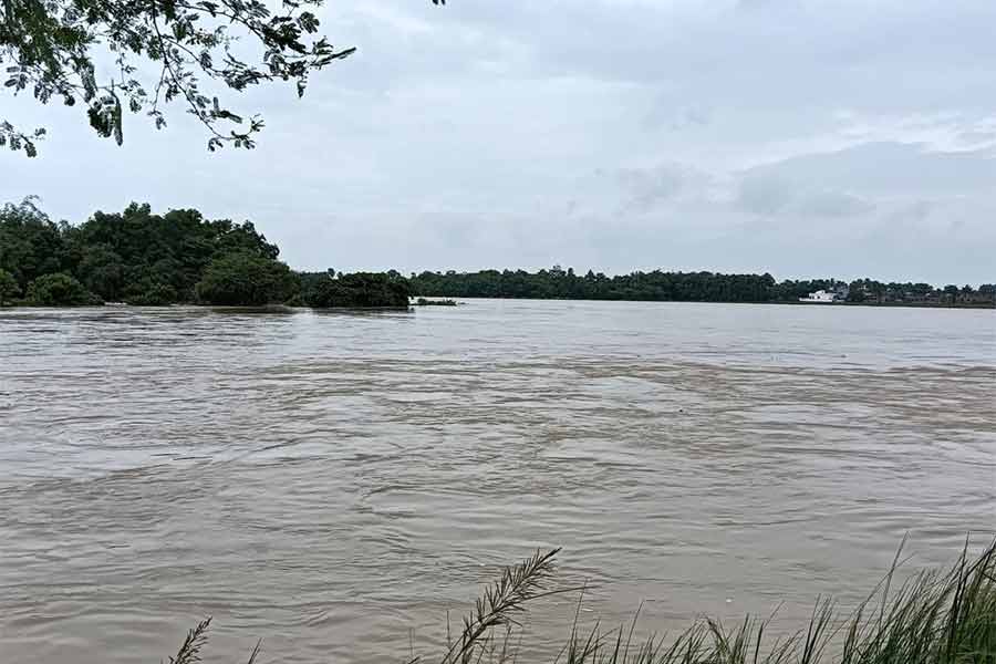 লাভপুরে কুঁয়ে নদীতে জল বাড়ছে। (ডান দিকে), বালির বস্তা দিয়ে বাঁধ আটকানো চলছে।