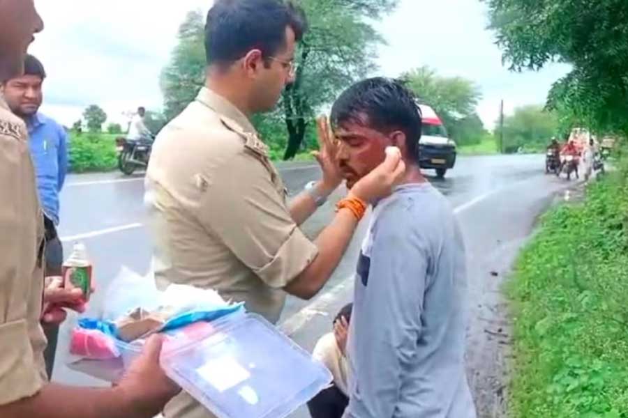 আহতের চিকিৎসা করছেন পুলিশ সুপার। ছবি: সংগৃহীত।