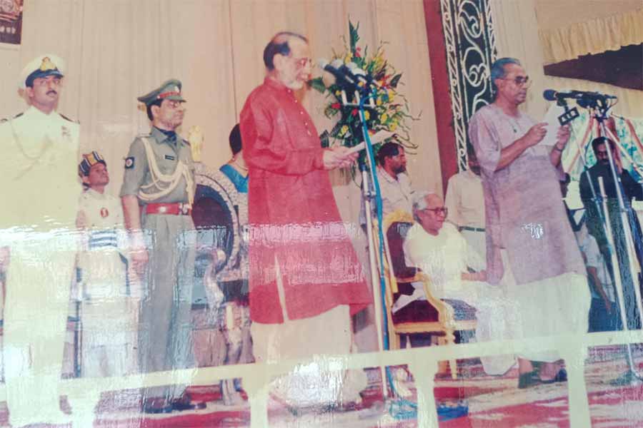 মন্ত্রী রেজ্জাক মোল্লার শপথগ্রহণ অনুষ্ঠানে পিছনে বসে তৎকালীন মুখ্যমন্ত্রী বুদ্ধদেব ভট্টাচার্য। ফাইল চিত্র 