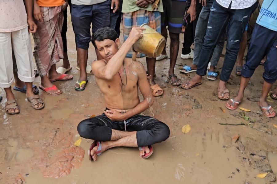 Local people take bath in stagnant water to protest agasint poor road condition in Baduria