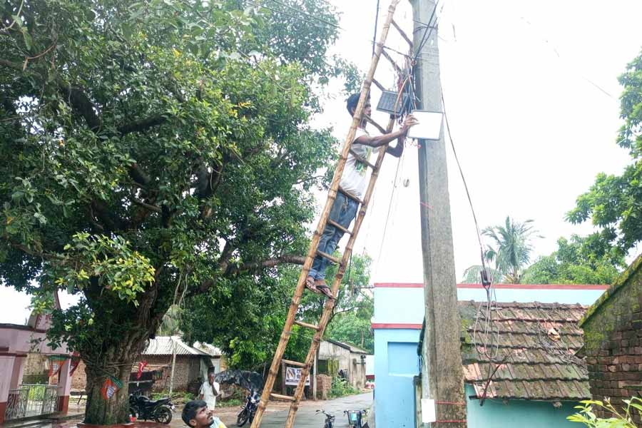 নান্দুর ঝাপানতলায় লাগানে হচ্ছে পথবাতি। নিজস্ব চিত্র