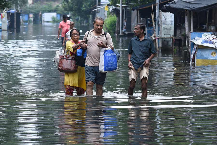 জলবন্দি: প্রায় হাঁটুসমান জল ঠেলেই গন্তব্যের পথে। সোমবার, হাওড়া ড্রেনের ক্যানাল রোডে।