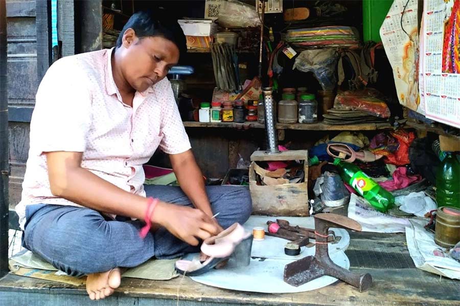 জুতো সেলাইয়ের কাজে মন দিয়েছেন সুভাষ। ছবি: নবেন্দু ঘোষ 