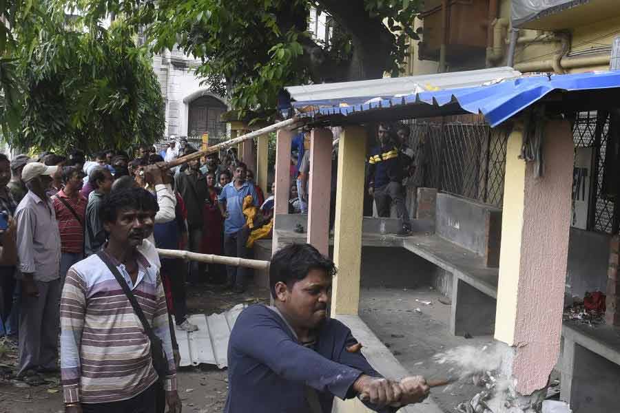 ক্ষোভ: বারাসত নবপল্লি কলোনি মোড়ে সেই অবৈধ নির্মাণ ভেঙে ফেলছেন সাধারণ মানুষ। রবিবার।