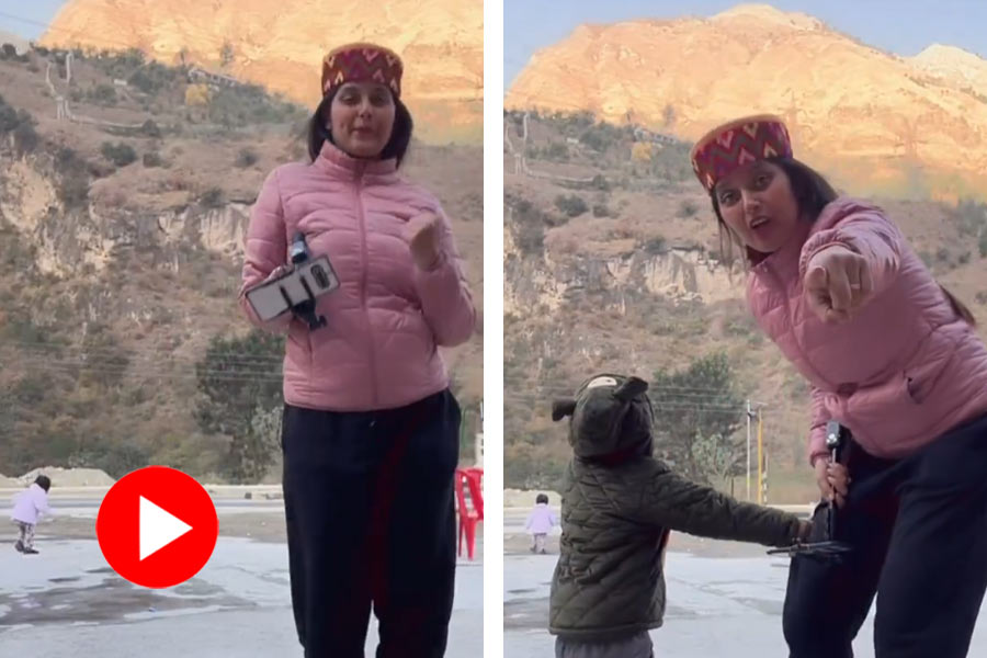 Video of children moves toward busy road while her mother making reel