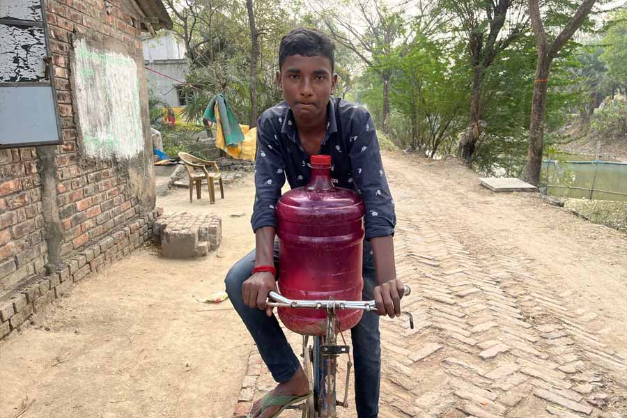 সাইকেল নিয়ে জল আনতে যাচ্ছে বেড়মজুরের এক কিশোর।