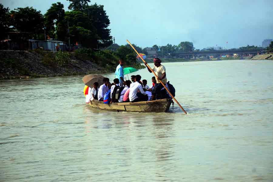 ভরা বর্ষায় মহানন্দা নদীতে নৌকায় পারাপার।