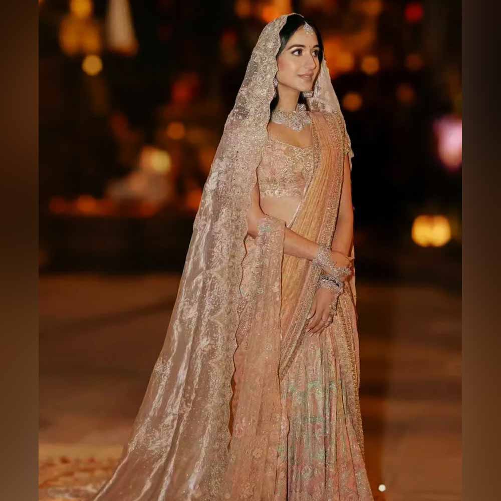 প্রথম প্রাক্‌-বিবাহ উদ্‌যাপনের সময়ে ‘হস্তাক্ষর’ অনুষ্ঠানে রাধিকার সেই সাজে মুগ্ধ না হয়ে উপায় ছিল না। পোশাকশিল্পী তরুণ তাহিলানির নকশা করা কুসুমরঙা লেহঙ্গা-শাড়িতে সেজেছিলেন রাধিকা। সেই বেশে যখন হাজির হয়েছিলেন রাধিকা, সেখানে উপস্থিত সকলের চোখ রাধিকার দিকেই আটকে গিয়েছিল।