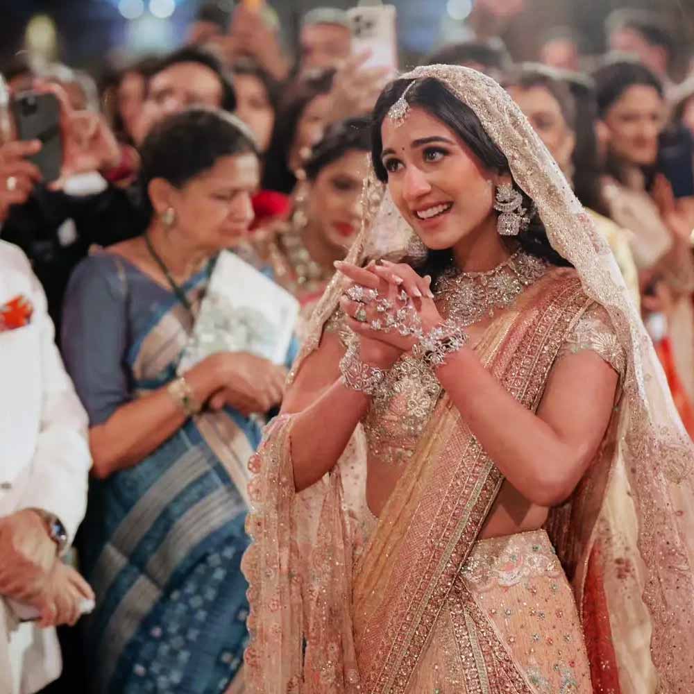 গোটা শাড়িটি হাতে তৈরি। শাড়ি জুড়ে নানা রঙের পাথর বসানো। লাল জরি শাড়ির সৌন্দর্য বাড়িয়ে দিয়েছিল। এমন চোখধাঁধানো পোশাকে রাধিকা হয়ে উঠেছিলেন মোহময়ী।