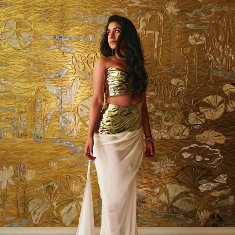 অনাবৃত গলায় হার না পরলেও, কানে লম্বা দুল পরেছিলেন। সঙ্গে মানানসই মেকআপ। কালো আইশ্যাডোয় ঢাকা চোখে উষ্ণতা মাখানো। অম্বানীদের বাড়ির হবু ছোট বৌয়ের একই অঙ্গে কত রূপ!