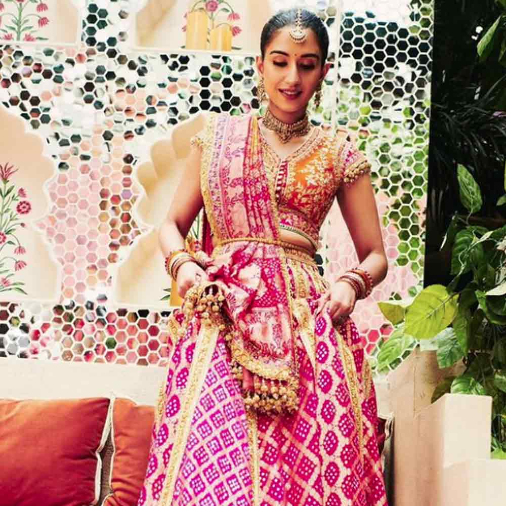 রাধিকার চুলের সাজও মন কাড়ে। কাঁধ ছাপানো বিনুনি সাজানো গয়নায়। গলায় চওড়া হার, কানে দুল, মাথায় টিকলি। দু’হাতে একগুচ্ছ চুড়ি। দুই ভ্রুর মাঝখানে ছোট্ট টিপ। এ দিনের পর বিয়ের দিন রাধিকার সাজ কেমন হবে, তা নিয়ে কৌতূহল আরও খানিকটা বেড়ে গিয়েছে।