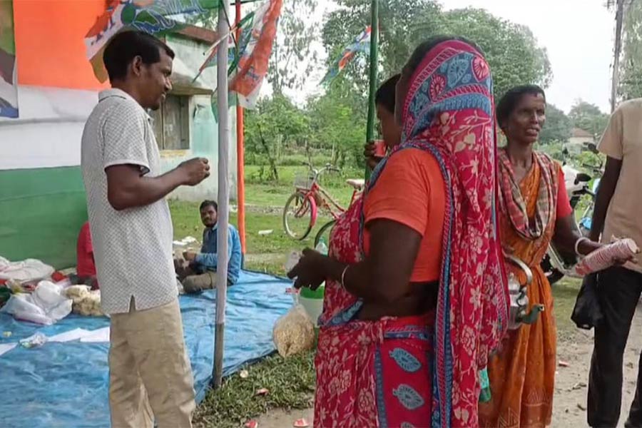 রায়গঞ্জের একটি বুথে ভোটারদের মুড়ি চানাচুর বিলি করা হচ্ছে। বুধবার রায়গঞ্জে।