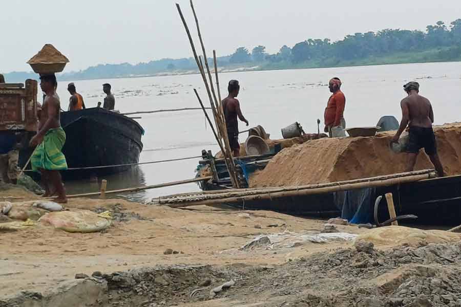 পলাশির তেজনগর ফেরিঘাটে নৌকা থেকে বালি খালি করা হচ্ছে। বৃহস্পতিবার দুপুরে।